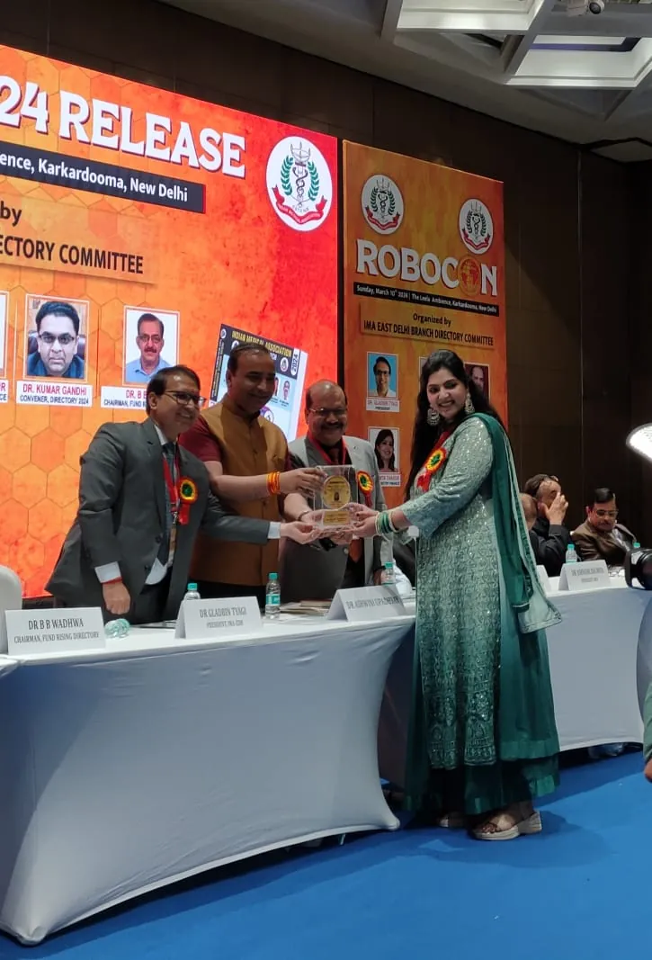 Dr. Neiha Bansal receiving a memento at an IMA East Delhi Branch event in Karkardooma, New Delhi