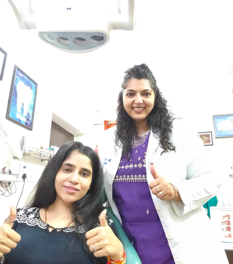 Dr. Neiha Bansal with a patient giving a thumbs-up in the dental chair