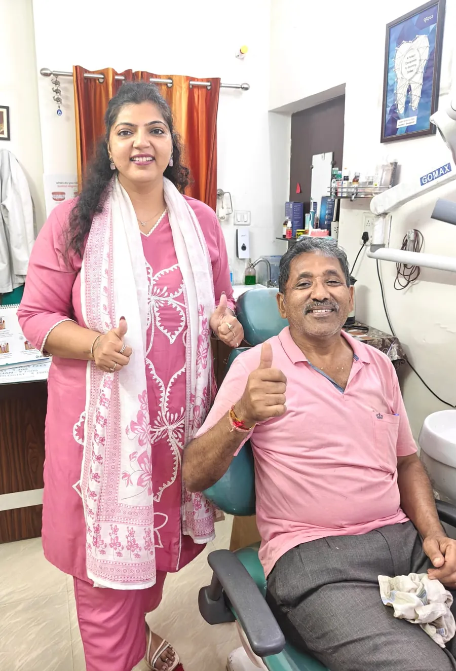 Dr. Neiha Bansal with a senior patient giving a thumbs-up in the dental chair