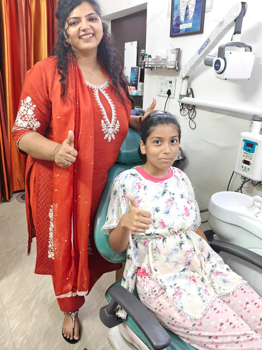 Dr. Neiha Bansal with a young patient giving a thumbs-up after her visit